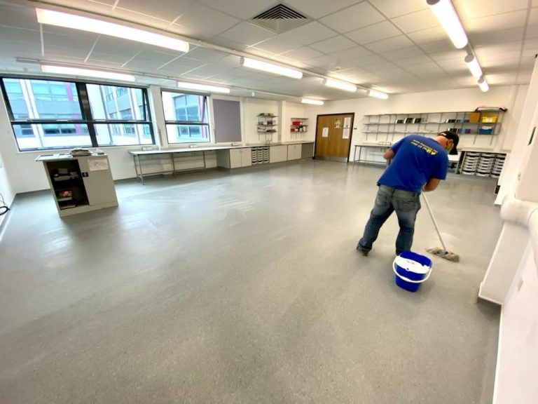 man mopping classroom floor